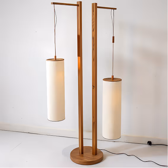 Modern wooden floor lamp with two cylindrical white fabric lampshades hanging from wooden arms.